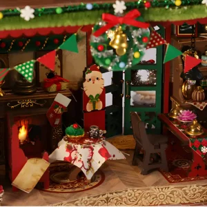 Cozy interior detail of Christmas cottage miniature with fireplace, dining set, and festive wreath decoration.