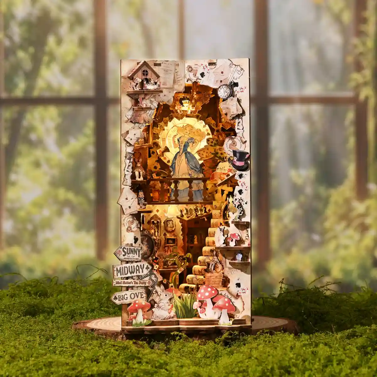 Alice in Wonderland book nook kit with warm LED lighting on moss
