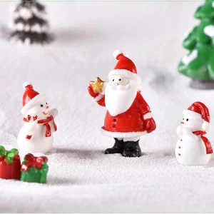 Santa Claus figurine holding yellow star with miniature snowmen for holiday display