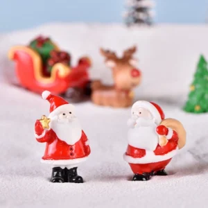 Two Santa Claus figurines standing in snow with reindeer sleigh for Christmas village accessories