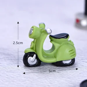 Green resin miniature motorcycle scooter model measuring 2.5cm height and 3cm length