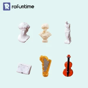 Renaissance miniature accessories featuring classical busts, harp, cello, and vintage newspaper props.
